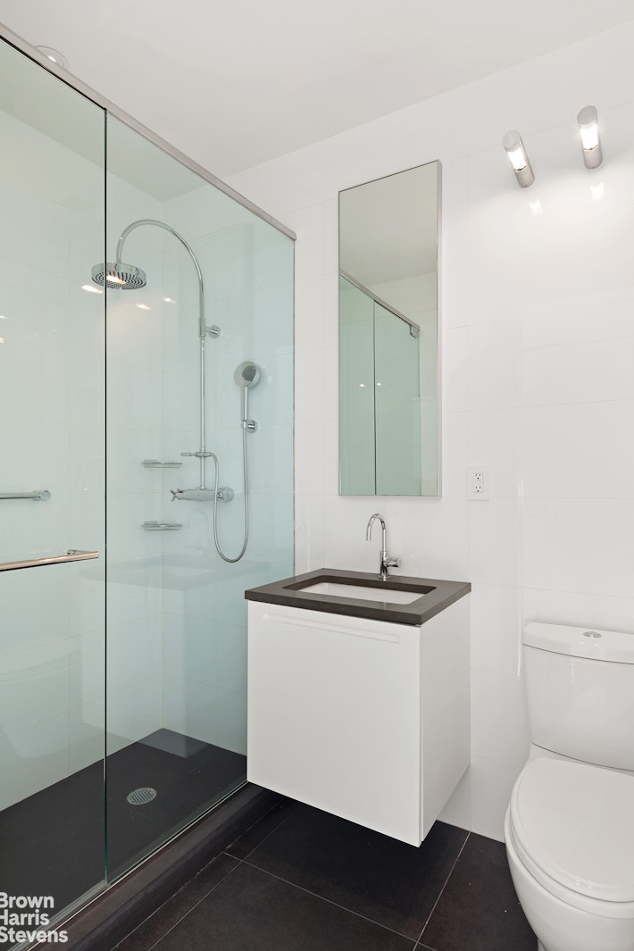 151 East 58th Street, Unit 43E Manhattan, NY 10022 - Photo 40 of 50 a bathroom with a sink a toilet and shower