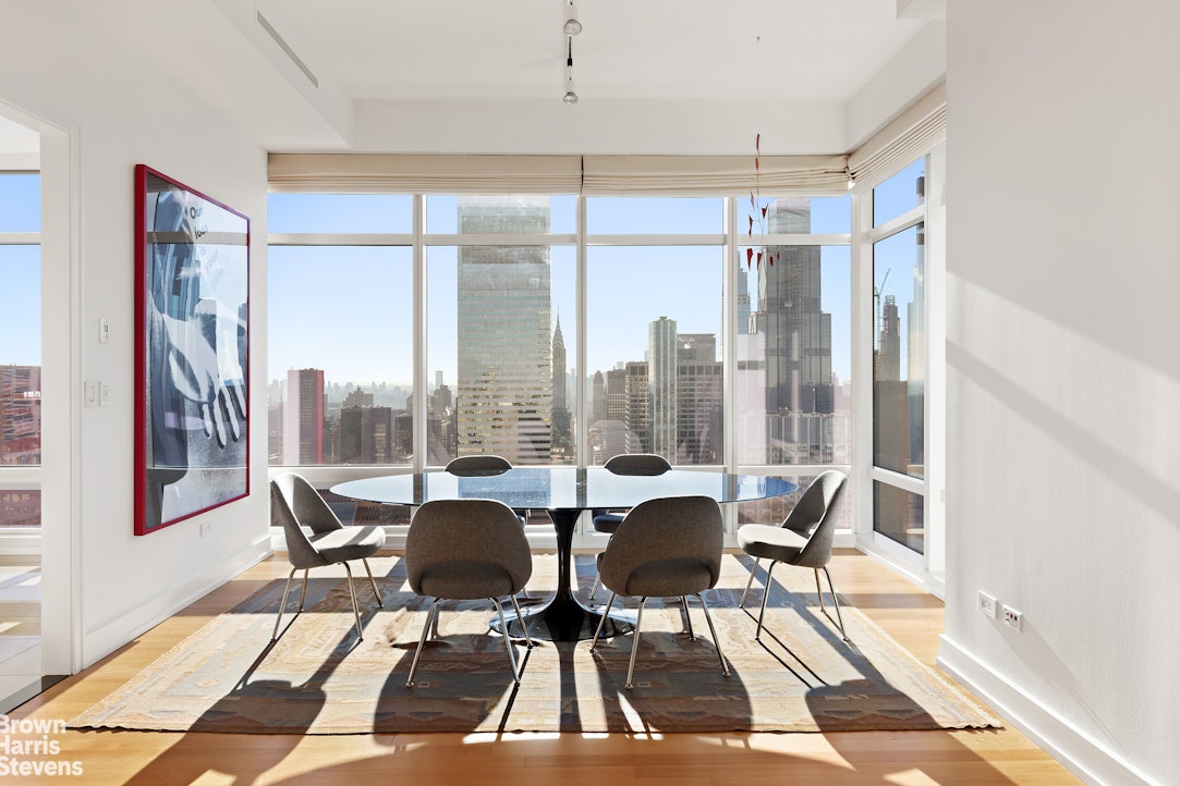 151 East 58th Street, Unit 43E Manhattan, NY 10022 - Photo 4 of 50 a dining room with furniture and a floor to ceiling window