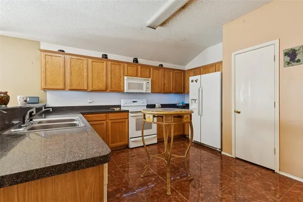 a kitchen with a refrigerator sink and cabinets