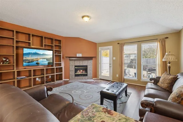 a living room with furniture a floor to ceiling window and a flat screen tv