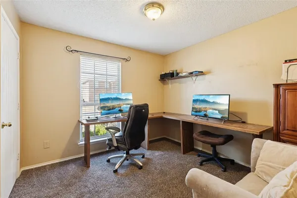 a view of a workspace with furniture and a window