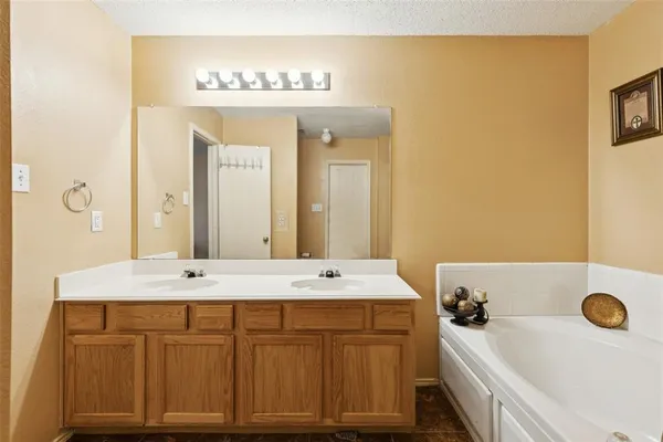 a bathroom with a tub a sink and a mirror