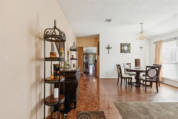 a dining room with furniture wooden floor a rug and a chandelier
