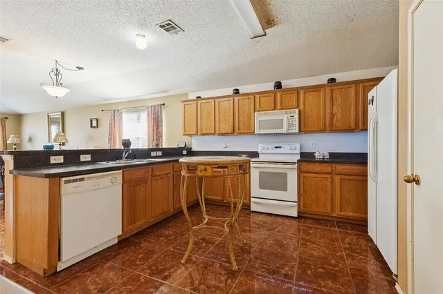 a kitchen with granite countertop a sink cabinets and stainless steel appliances