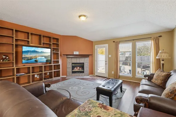 a living room with furniture a floor to ceiling window and a flat screen tv