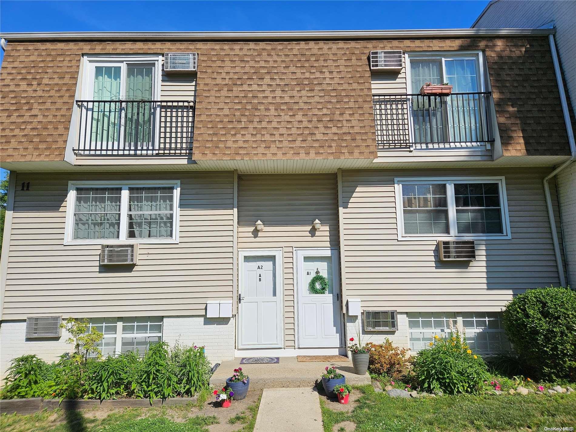 a view of a brick house with a yard and plants
