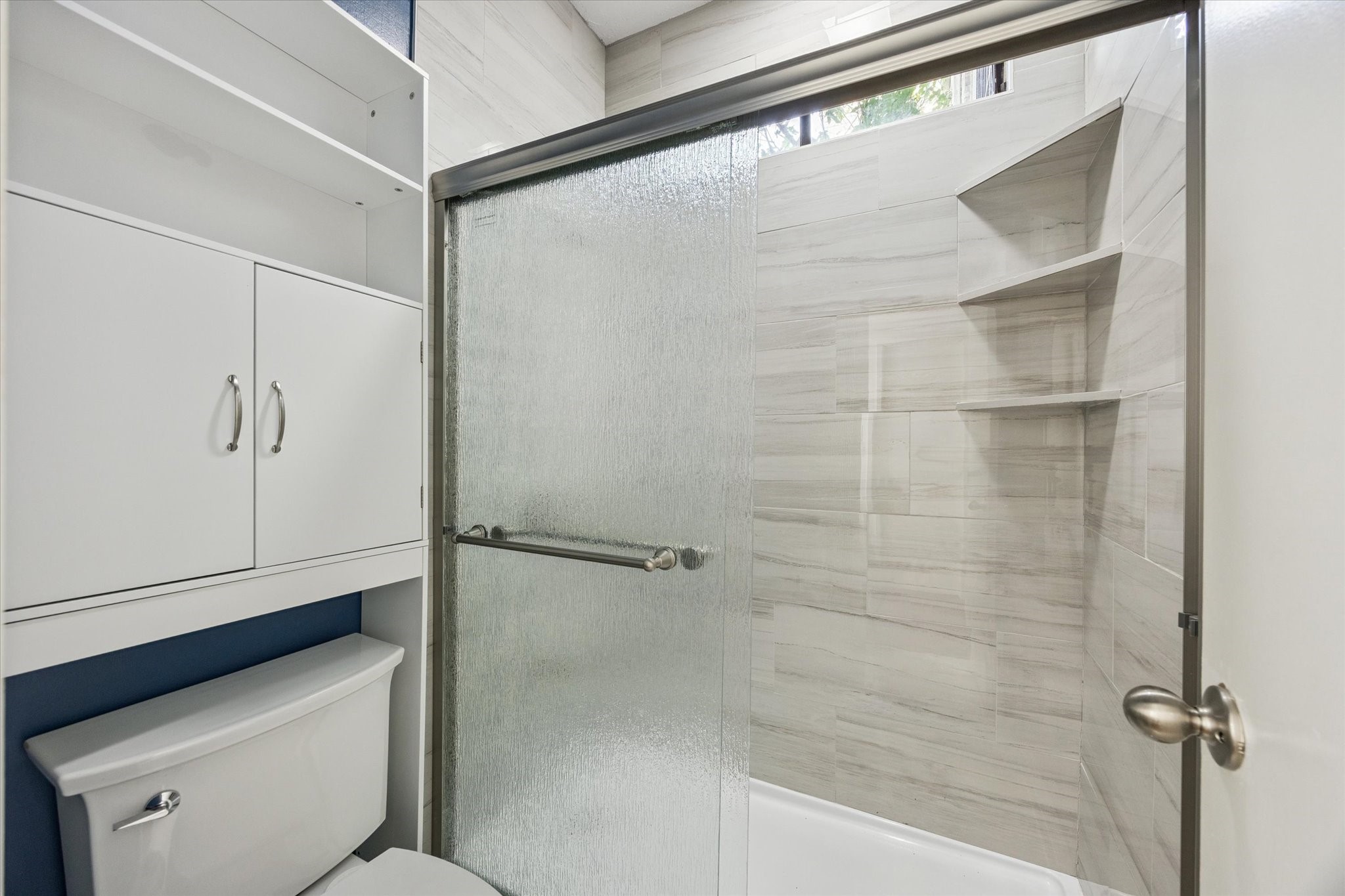 8100 Cambridge Street, Unit 123 Houston, TX 77054 - Photo 13 of 31 Updated bathroom with a tub/shower combo and convenient storage cabinet above the toilet.