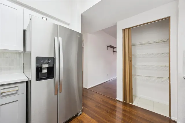 a view of a hallway with wooden floor and cabinets