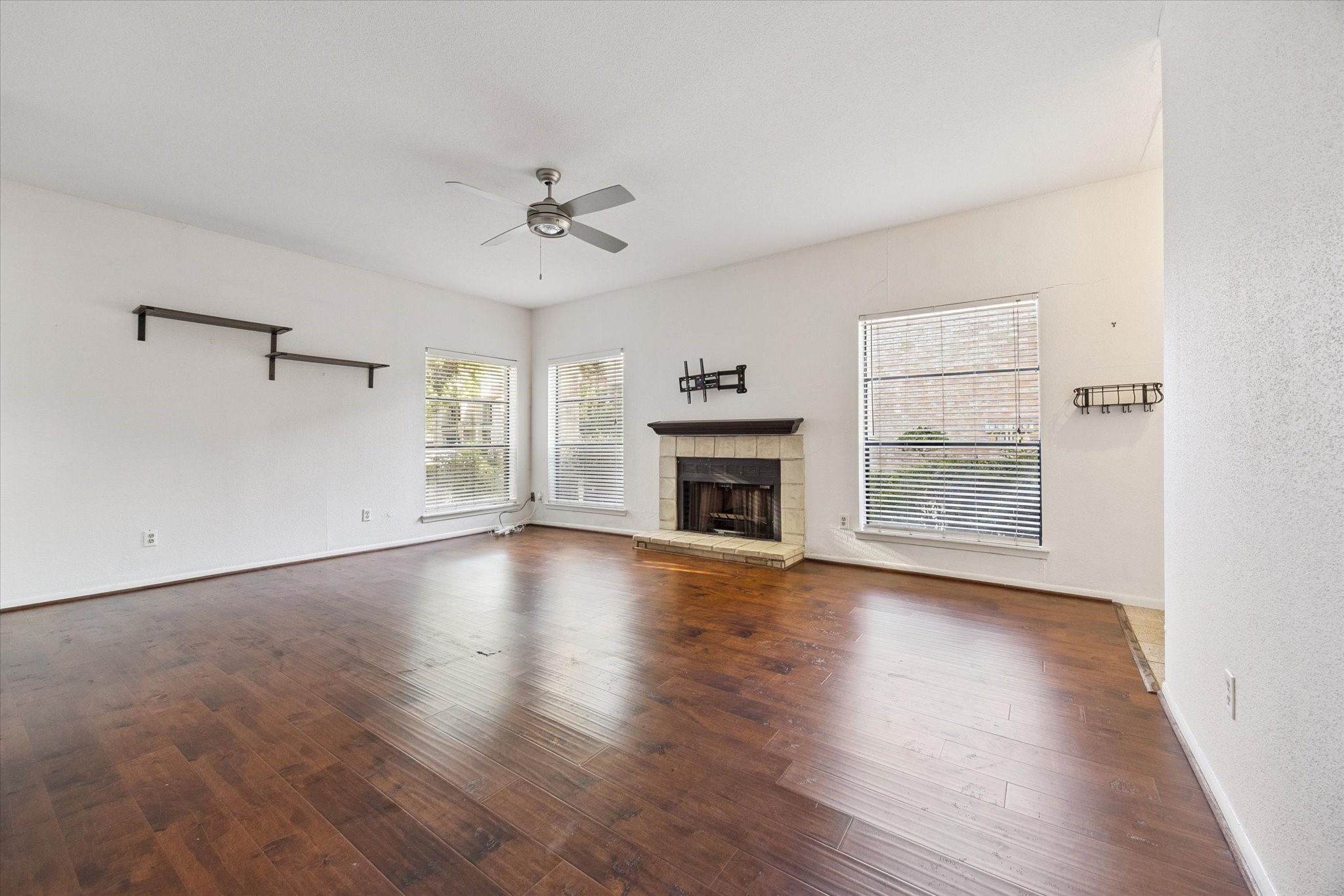 8100 Cambridge Street, Unit 123 Houston, TX 77054 - Photo 10 of 31 an empty room with wooden floor fireplace and windows