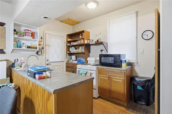 a kitchen with stainless steel appliances granite countertop a sink dishwasher and a refrigerator with wooden floor