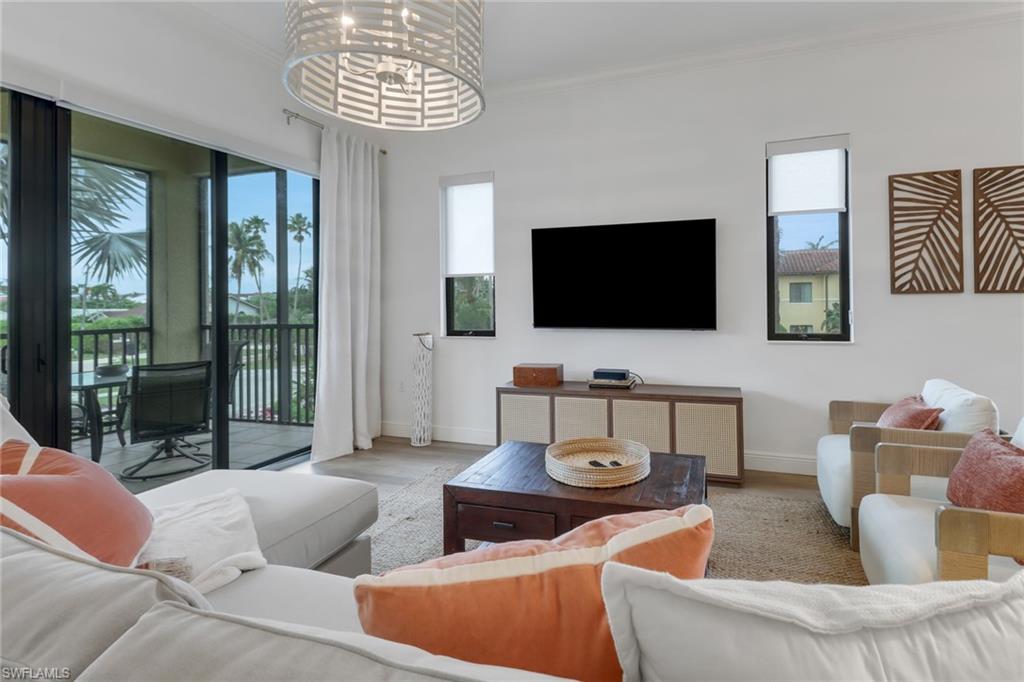 985 Sandpiper Street, Unit I204 Naples, FL 34102 - Photo 11 of 45 a living room with furniture and a flat screen tv