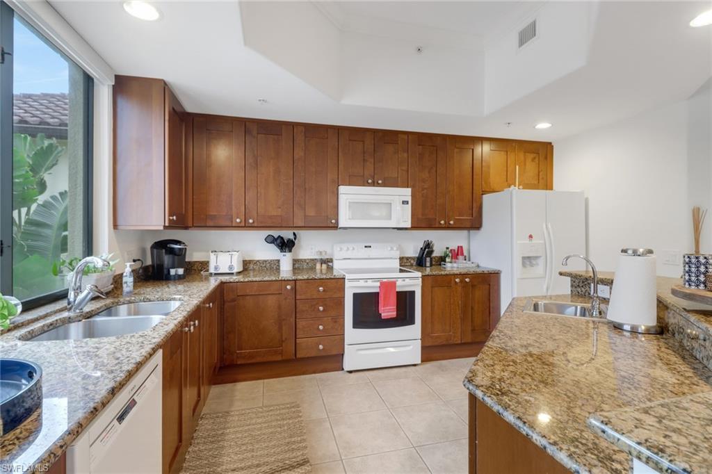 985 Sandpiper Street, Unit I204 Naples, FL 34102 - Photo 15 of 45 a large kitchen with stainless steel appliances granite countertop a stove sink and cabinets