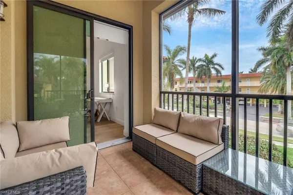 a balcony with furniture and a potted plant
