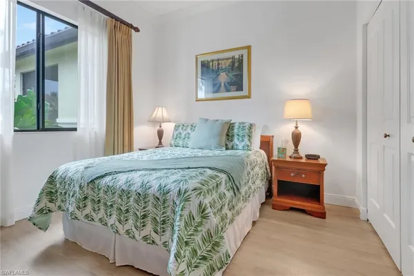 a bed sitting in a bedroom next to a window