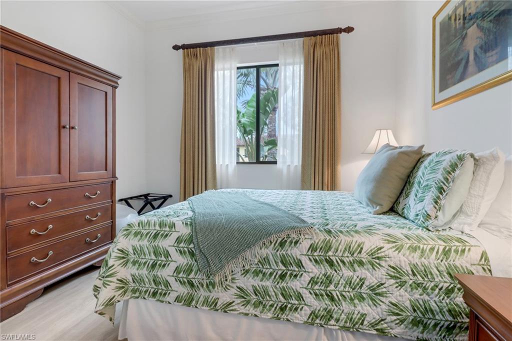 985 Sandpiper Street, Unit I204 Naples, FL 34102 - Photo 20 of 45 a bed sitting in a bedroom next to a window