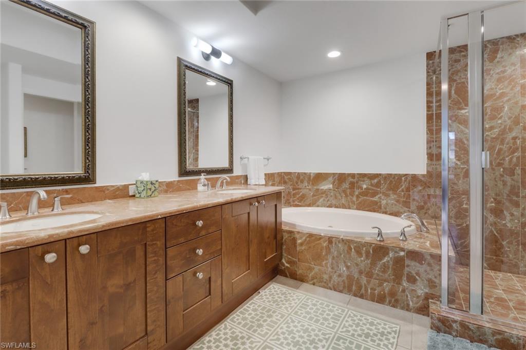 985 Sandpiper Street, Unit I204 Naples, FL 34102 - Photo 21 of 45 a spacious bathroom with a tub sink and mirror