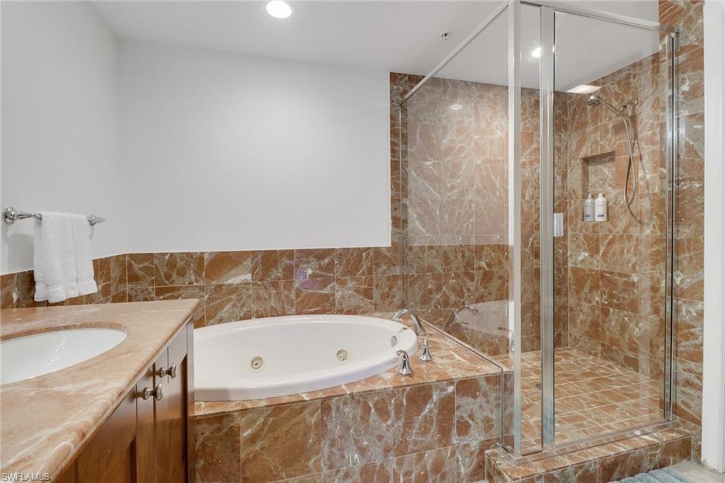 985 Sandpiper Street, Unit I204 Naples, FL 34102 - Photo 23 of 45 a bathroom with a granite countertop sink a mirror and shower