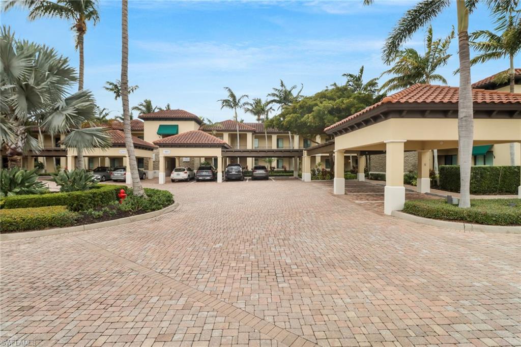 985 Sandpiper Street, Unit I204 Naples, FL 34102 - Photo 31 of 45 a view of a white house with a yard and potted plants