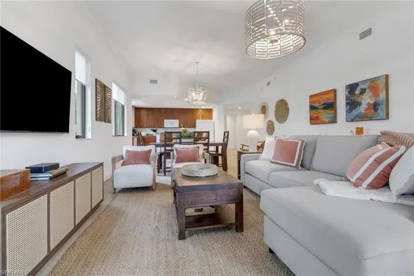 a living room with furniture kitchen view and a flat screen tv