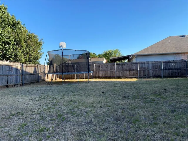 a view of a backyard with wooden fence