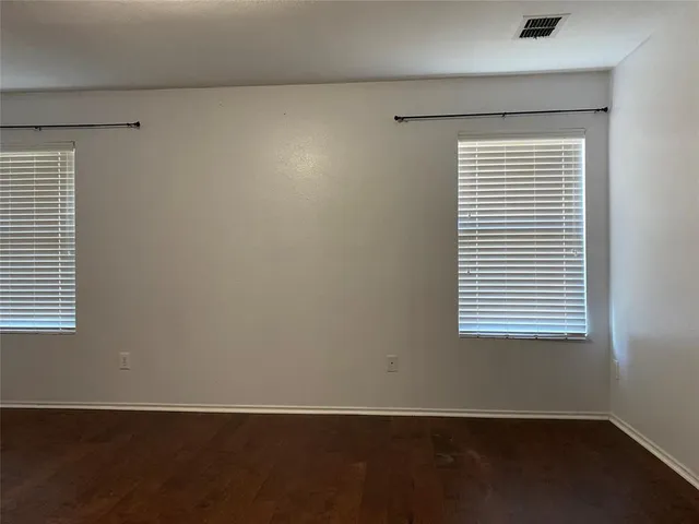 an empty room with wooden floor and a window