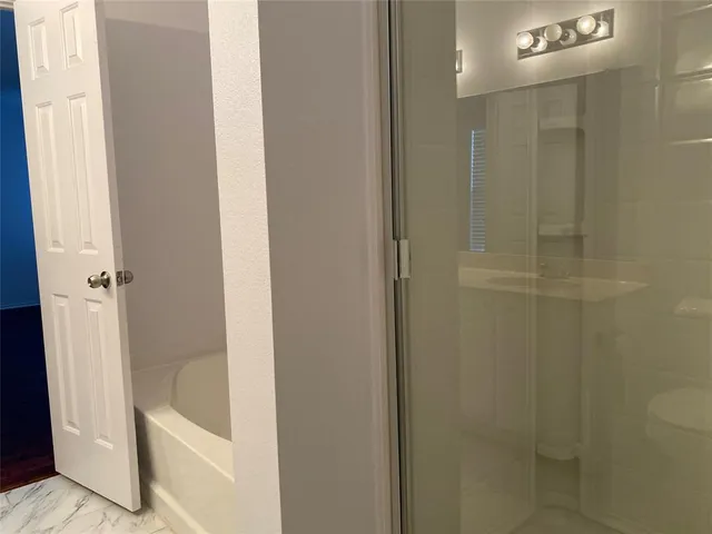 a bathroom with a tub a toilet and a shower