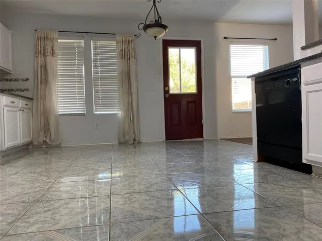 a view of an empty room with window and bathroom