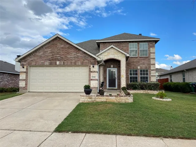 a front view of a house with a garden and yard