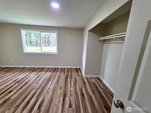 a view of a room with wooden floor and window