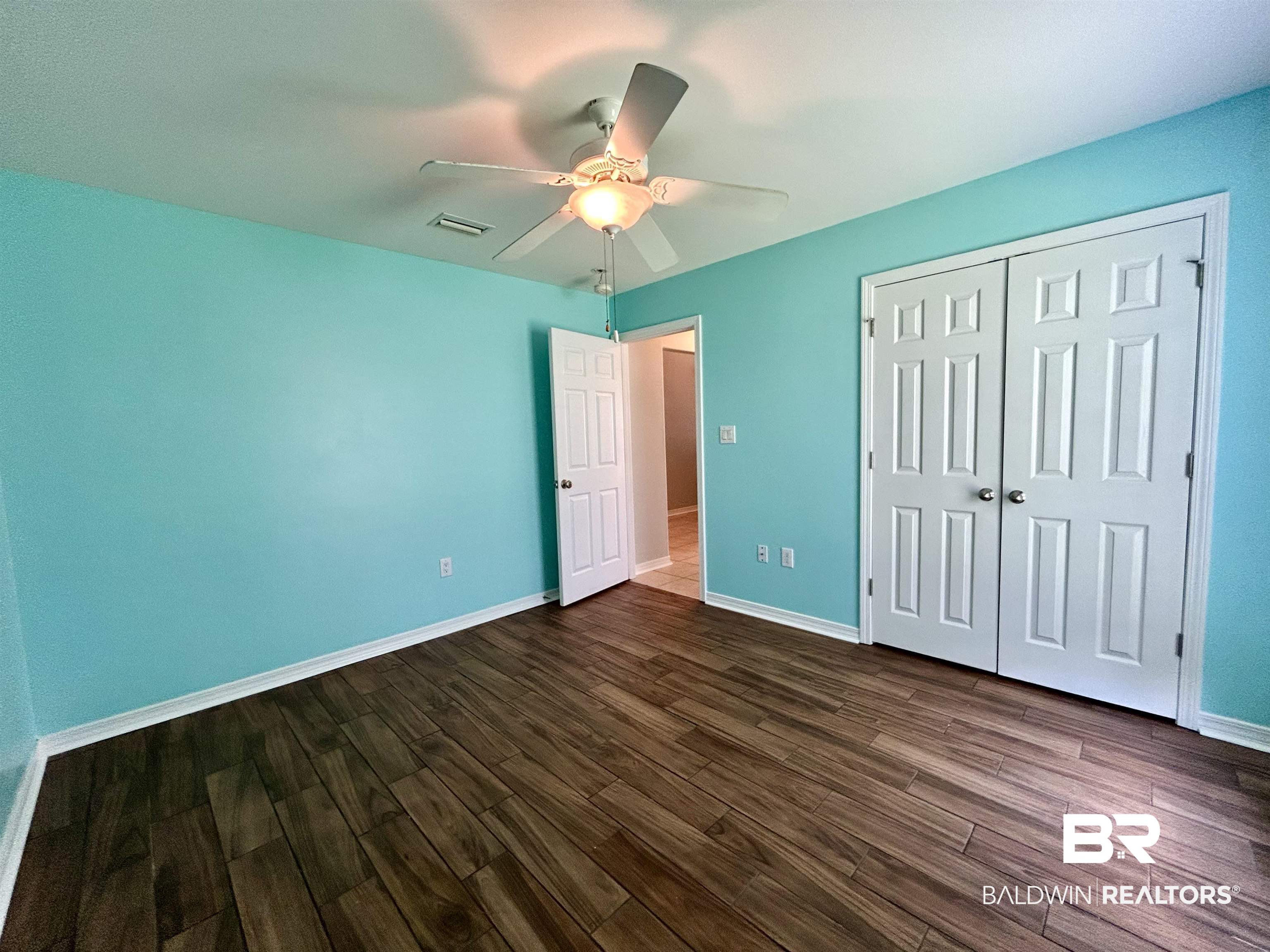 7198 Raintree Lane Gulf Shores, AL 36542 - Photo 25 of 33 Room featuring wood-look flooring and light blue walls