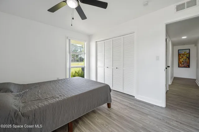 a bedroom with a bed and wooden floor
