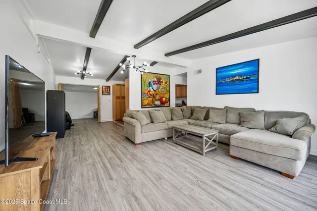a living room with furniture flat screen tv and wooden floor