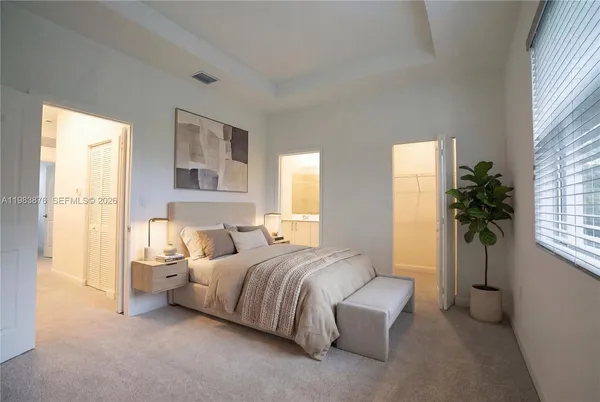 a bedroom with a bed and a couch next to a window