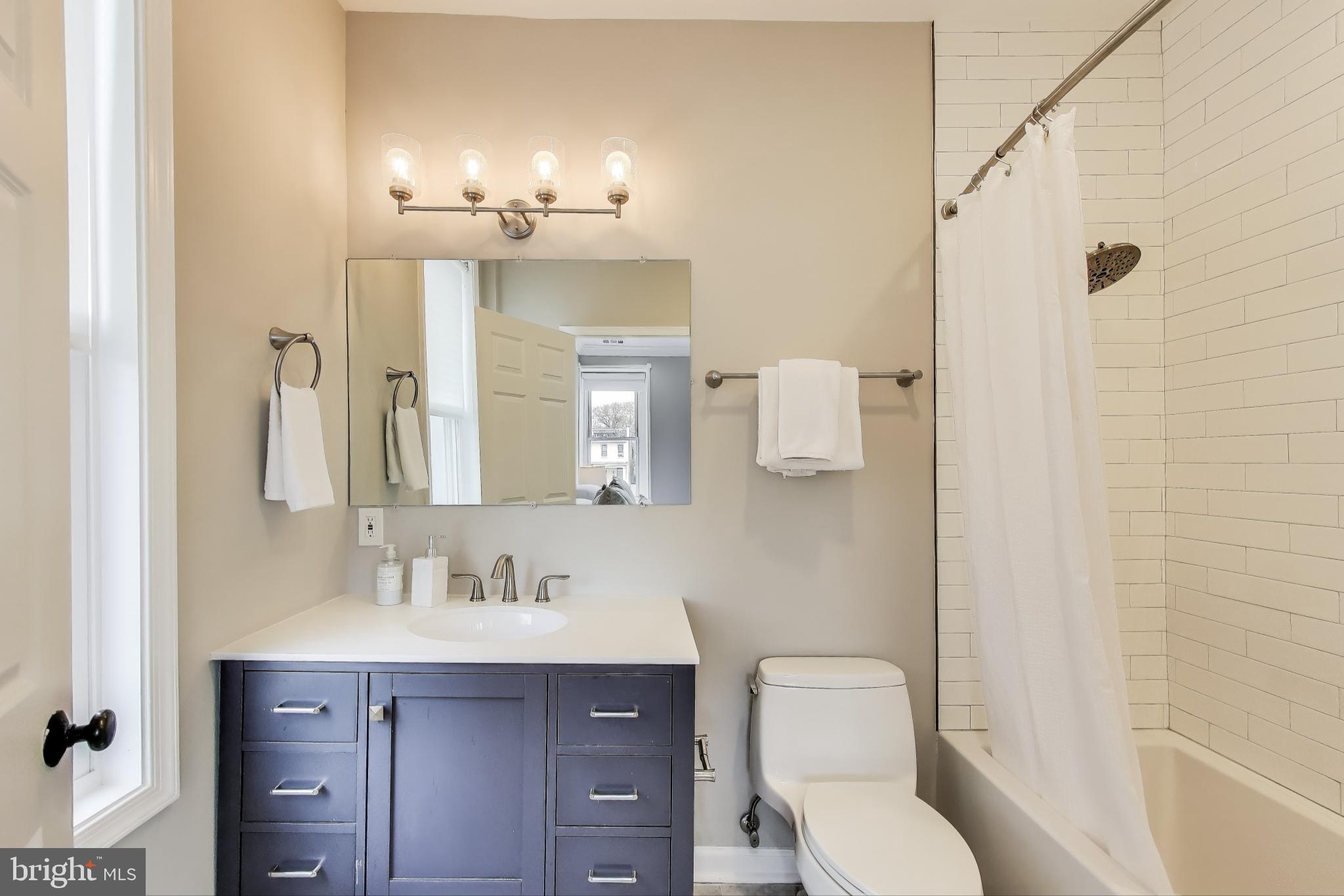 1415 G Street Southeast Washington, DC 20003 - Photo 15 of 42 a bathroom with a toilet a sink a mirror a shower and vanity