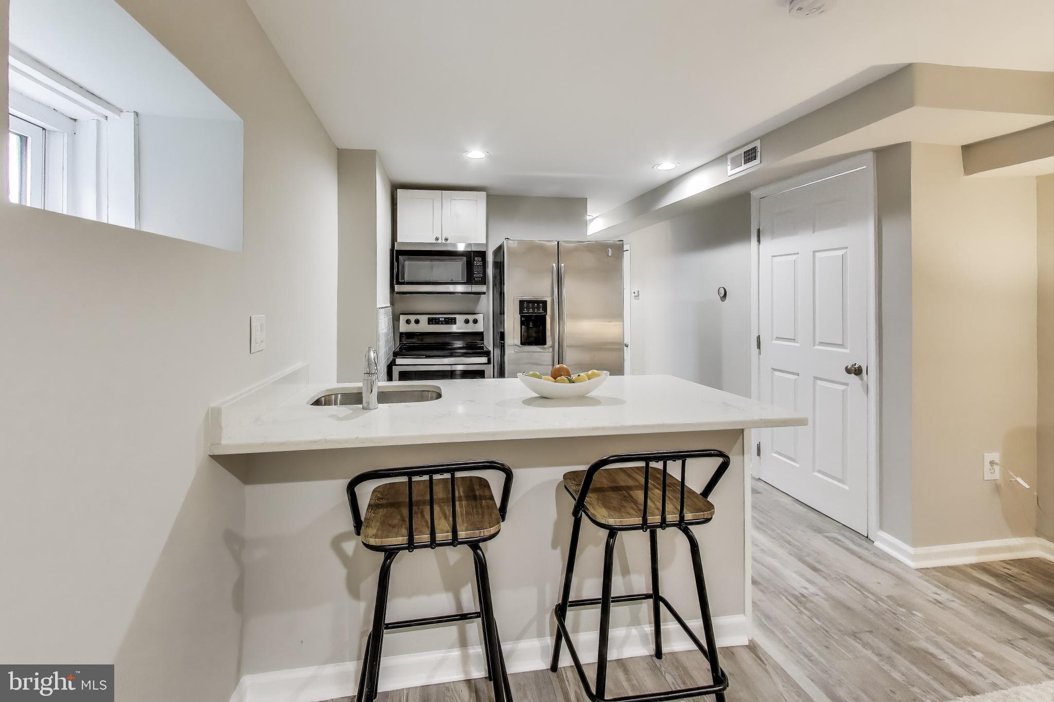 1415 G Street Southeast Washington, DC 20003 - Photo 24 of 42 a kitchen with stainless steel appliances a dining table chairs and wooden floor