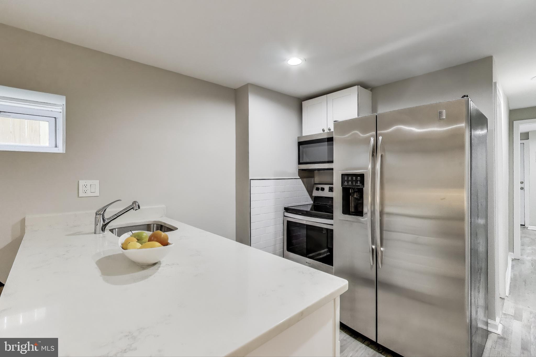 1415 G Street Southeast Washington, DC 20003 - Photo 25 of 42 a kitchen with kitchen island a refrigerator and a sink