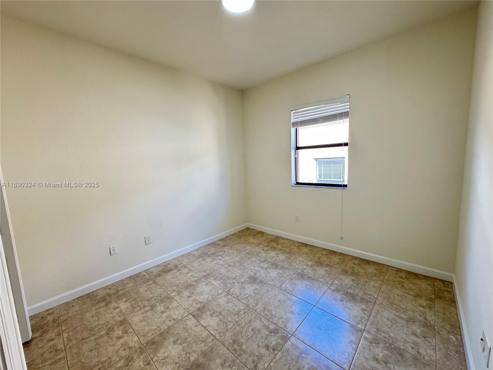 11291 Southwest 240 Lane Homestead, FL 33032 - Photo 14 of 22 an empty room with a window