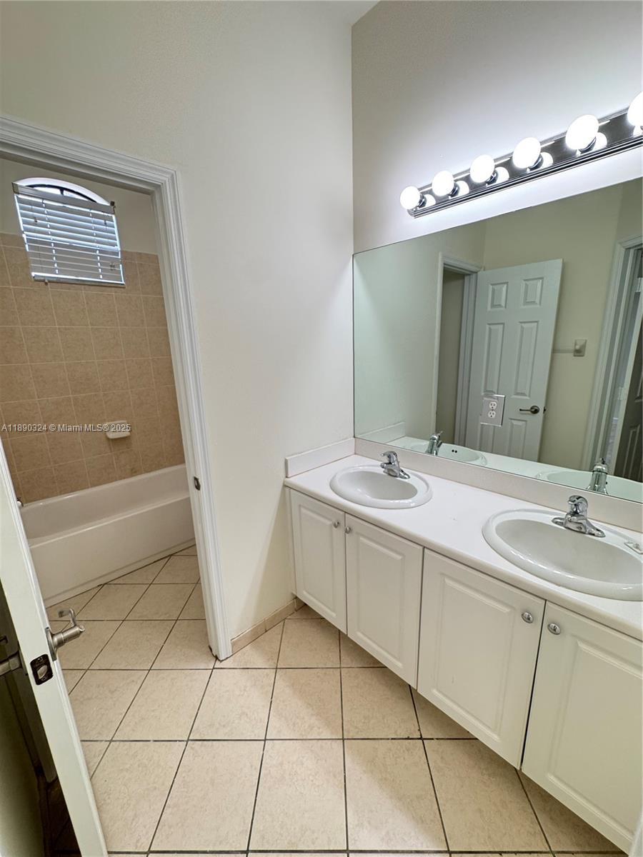 11291 Southwest 240 Lane Homestead, FL 33032 - Photo 15 of 22 a bathroom with a double vanity sink a mirror and a bathtub