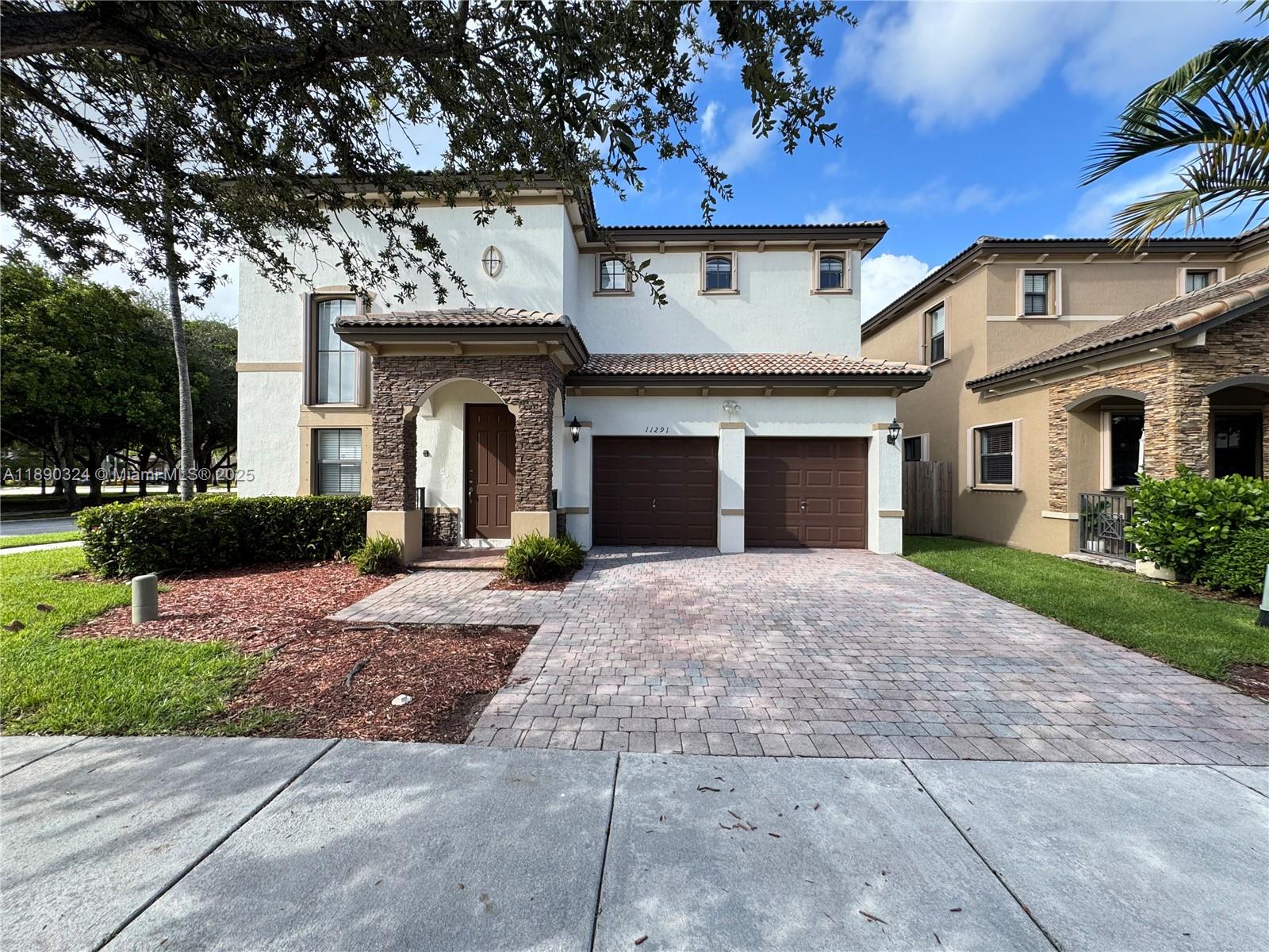 11291 Southwest 240 Lane Homestead, FL 33032 - Photo 2 of 22 a front view of a house with a yard and garage