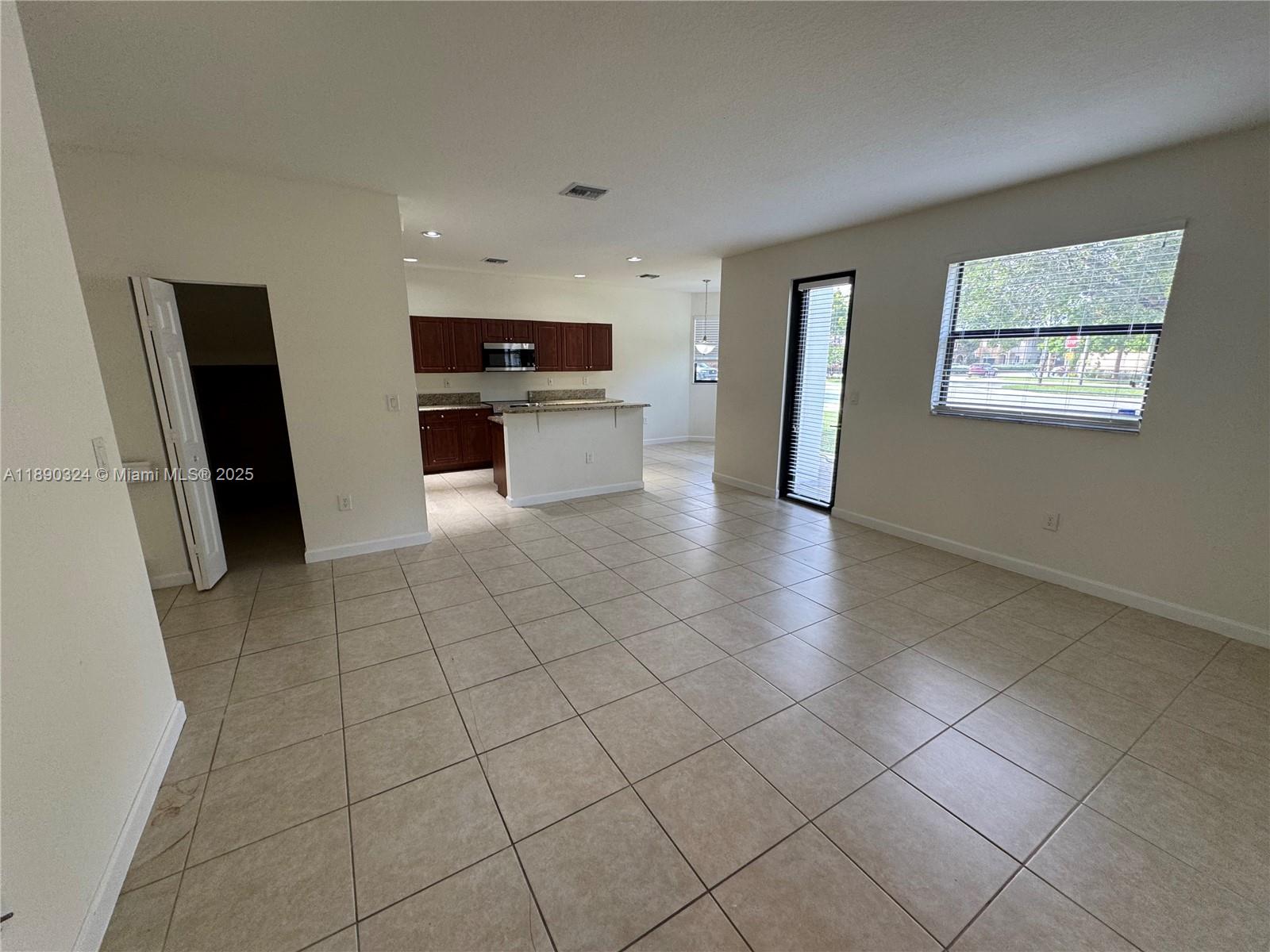 11291 Southwest 240 Lane Homestead, FL 33032 - Photo 4 of 22 a view of an empty room with kitchen and window