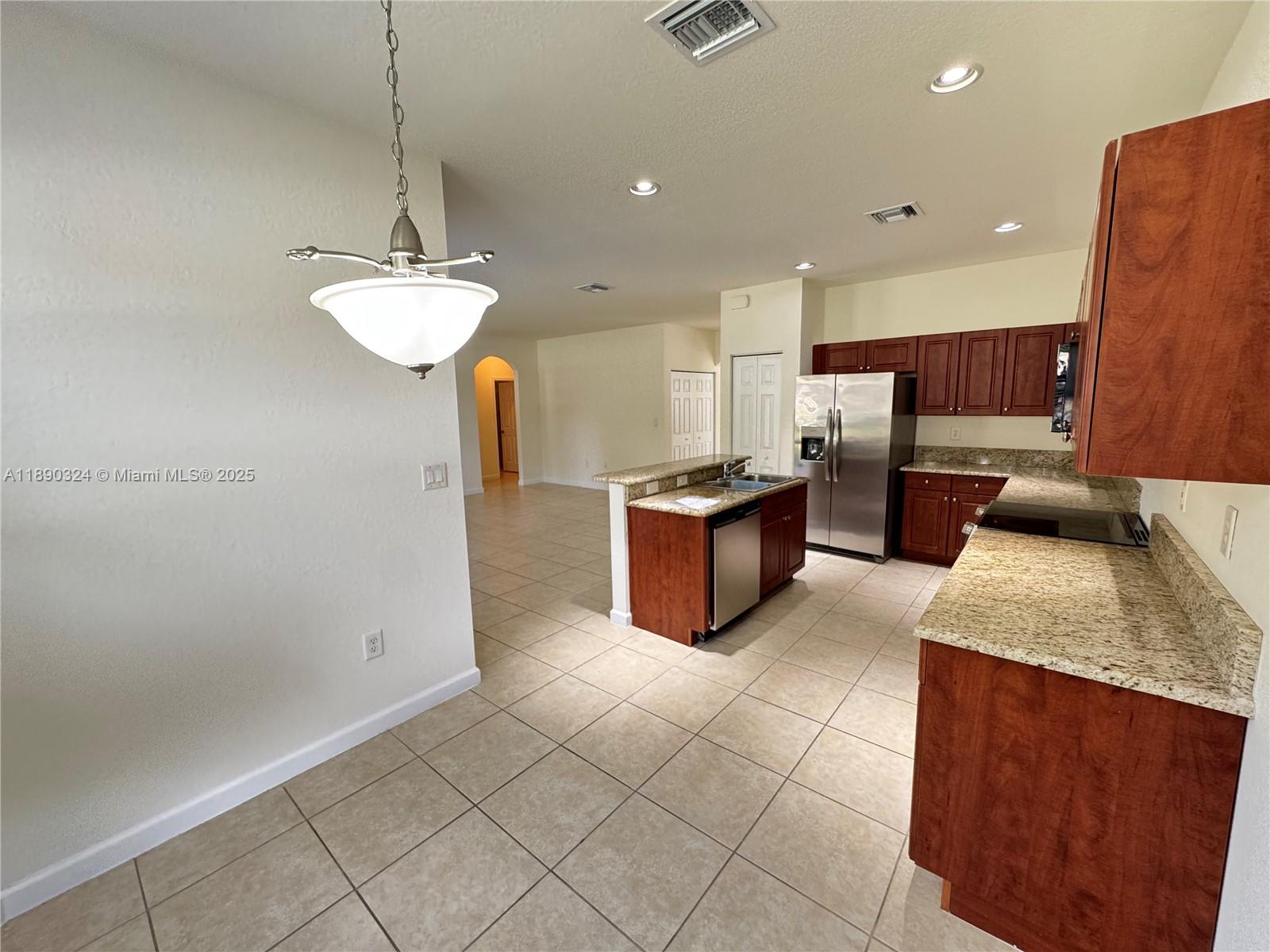 11291 Southwest 240 Lane Homestead, FL 33032 - Photo 5 of 22 a kitchen with stainless steel appliances granite countertop a sink a stove and a refrigerator