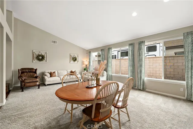 a living room with furniture kitchen view and a chandelier