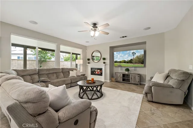 a living room with furniture kitchen view and a large window