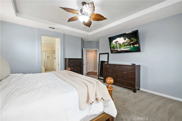 a bedroom with a bed and a flat tv screen on dresser