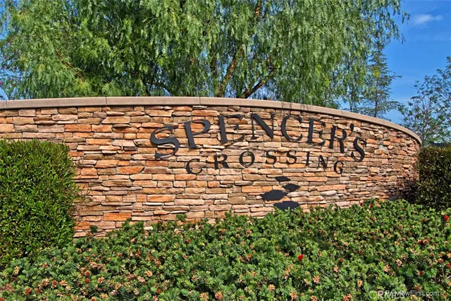 a view of a patio with table and chairs under an umbrella with a small yard