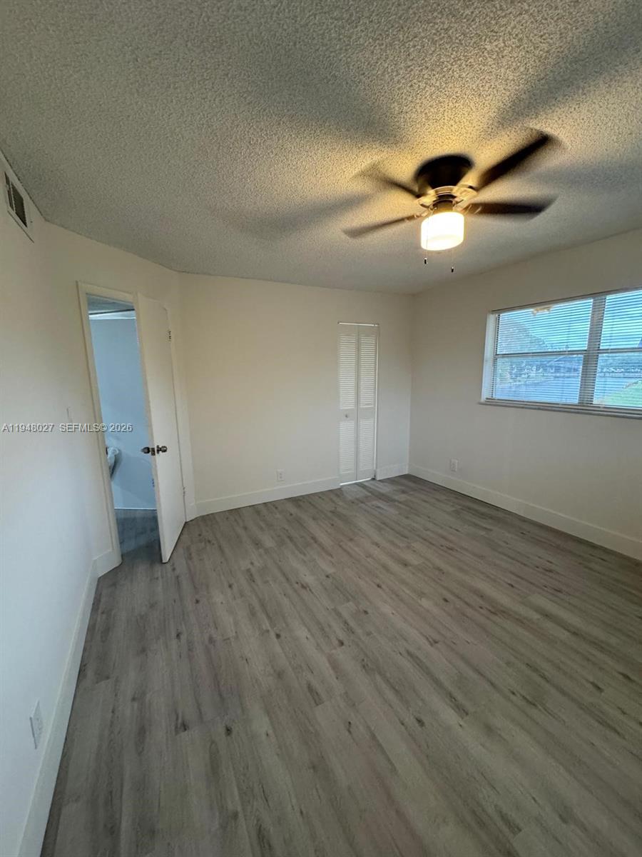 8051 South Colony Circle, Unit 210 Tamarac, FL 33321 - Photo 15 of 25 an empty room with wooden floor and windows