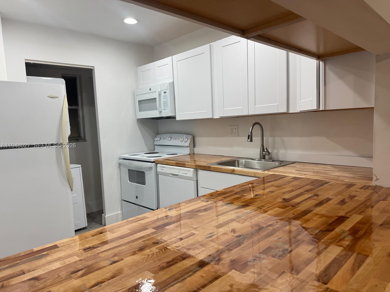 8051 South Colony Circle, Unit 210 Tamarac, FL 33321 - Photo 3 of 25 a kitchen with stainless steel appliances granite countertop a refrigerator sink and cabinets