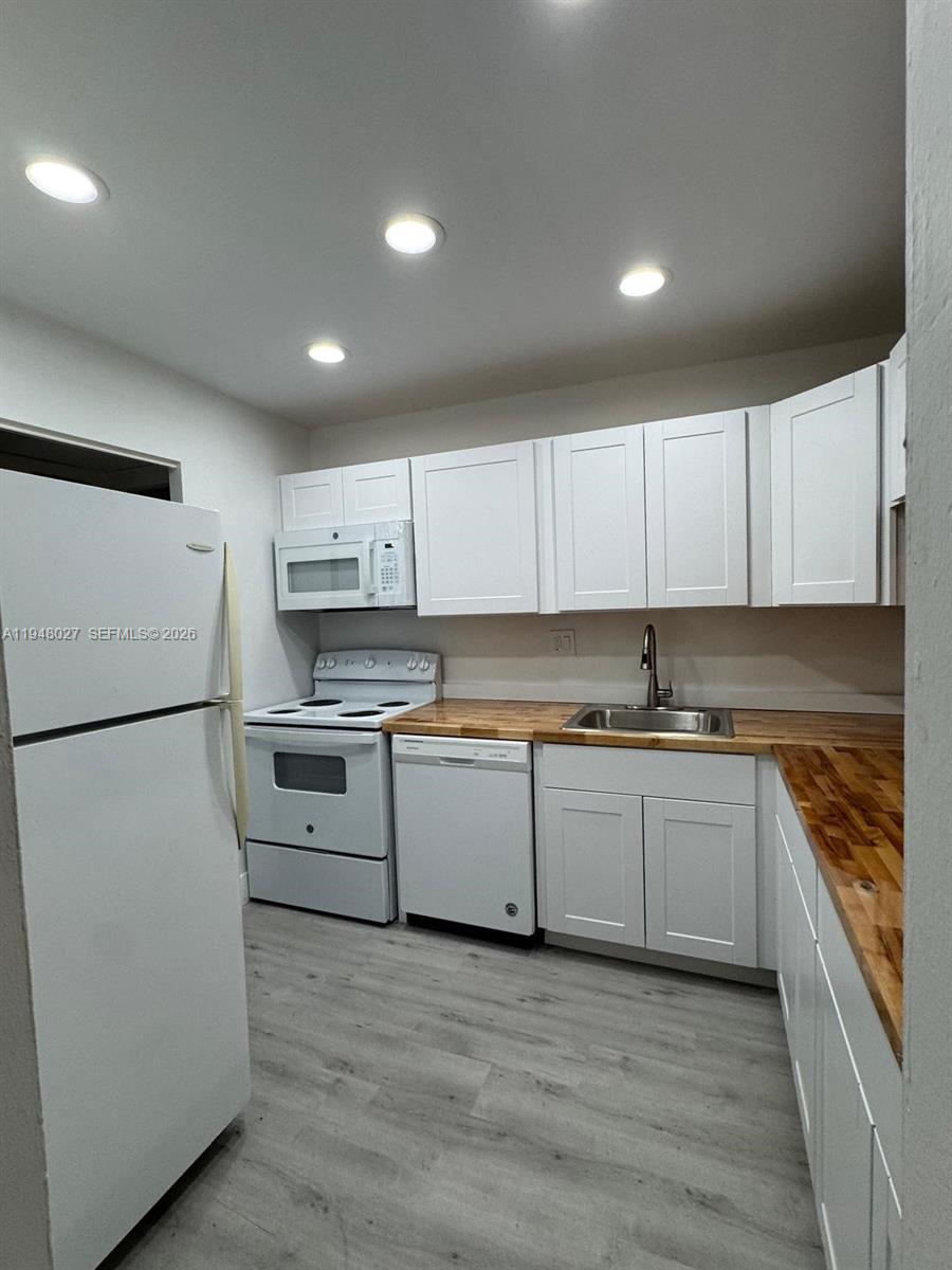 8051 South Colony Circle, Unit 210 Tamarac, FL 33321 - Photo 5 of 25 a kitchen with a refrigerator a stove top oven and white cabinets