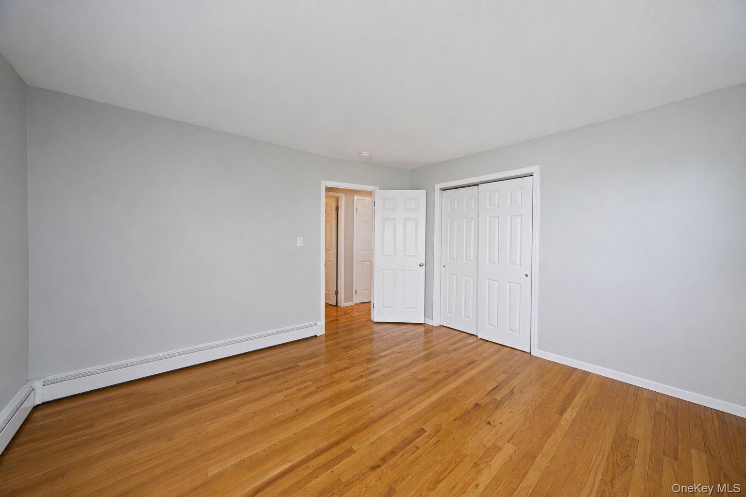 31 Crooked Hill Road Huntington, NY 11743 - Photo 11 of 32 Room featuring light wood-finish flooring, light grey painted walls, and white baseboards