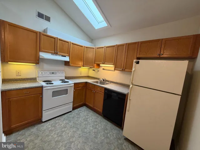 a kitchen with a refrigerator sink stove and cabinets